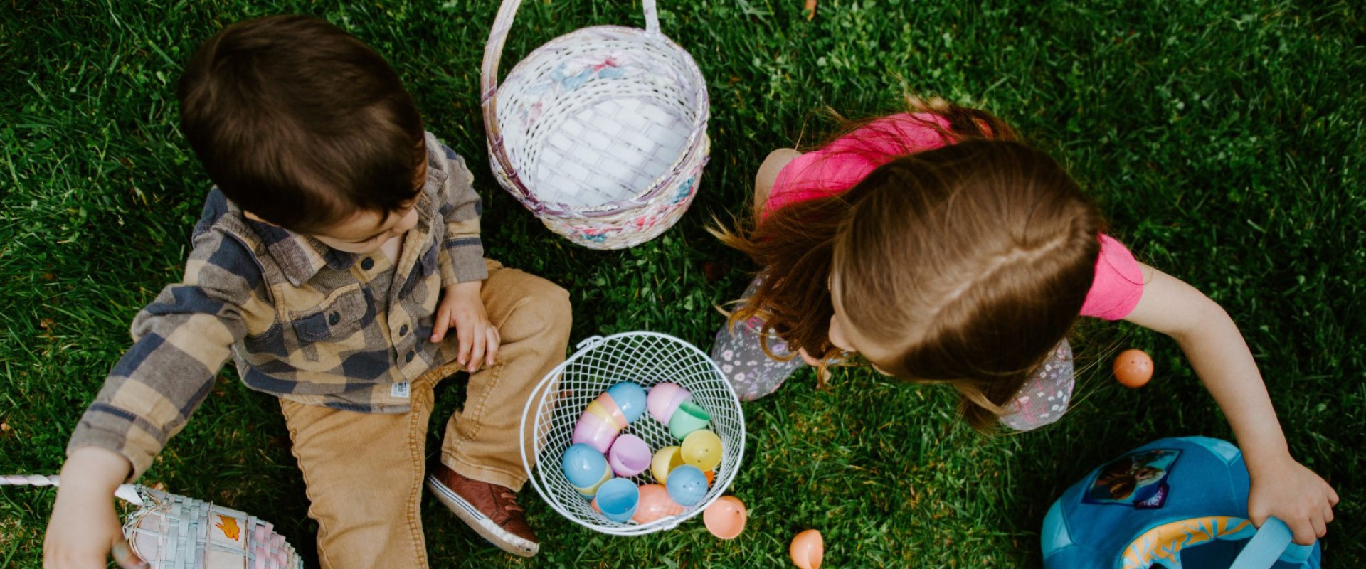 article image: Easter holidays 2023 in Portugal. Pictured are two children on the grass during an egg hunt activity.